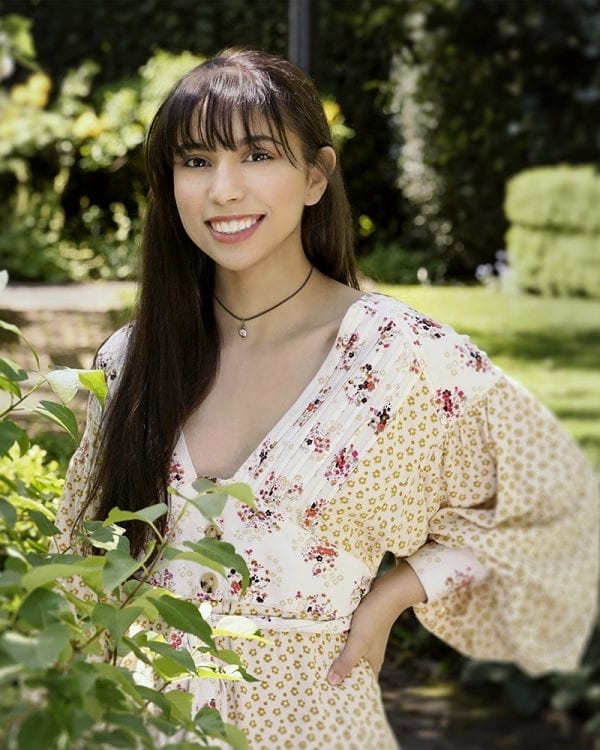 Portrait of a teen in a light dress outside with a hand on her hip