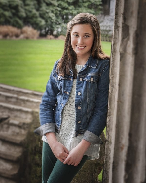 Portrait of a teen girl leaning against a roman column