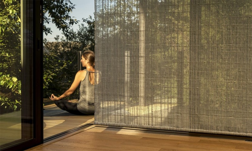 Tranquil setting with a translucent screen and a woman in a meditation pose