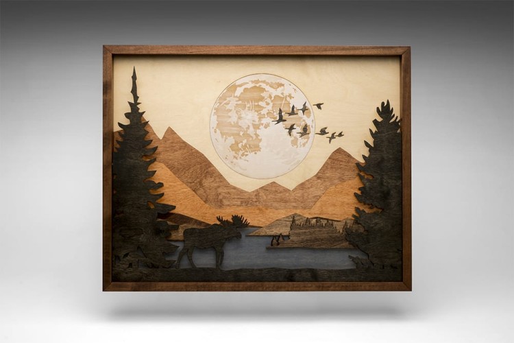 wooden art of a nature landscape with elk, trees, a lake, mountains, the moon, and birds
