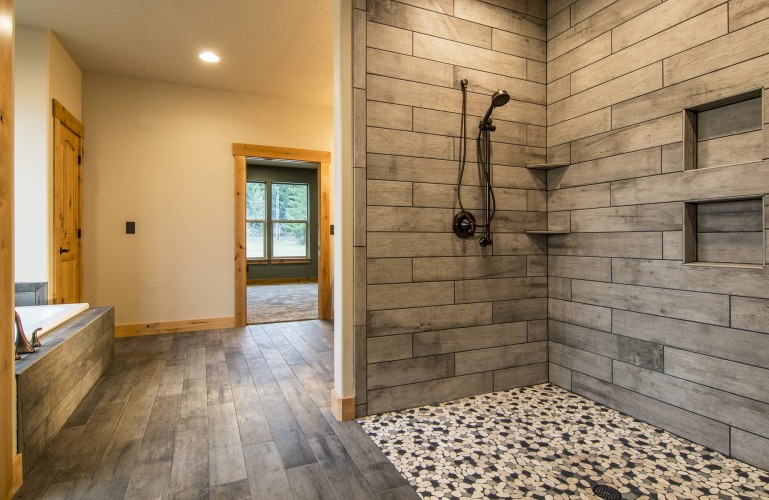 Gray wood and tile bathroom with a separate shower and bath