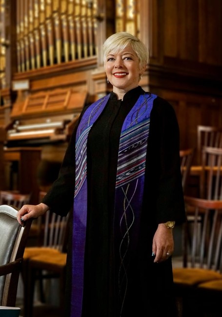 Full-body portrait of female pastor in a church with an organ