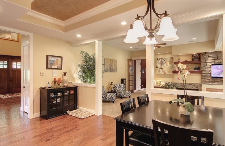 Dining room going into the living room with light walls and dark furniture