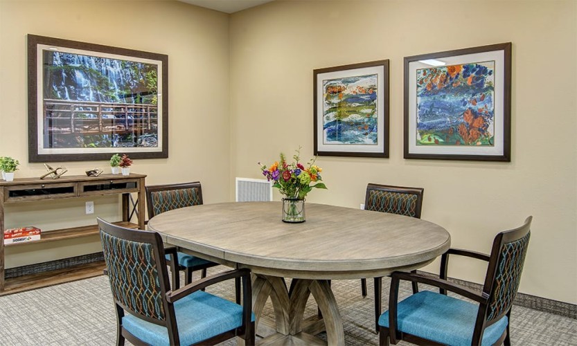 Game area with blue, orange, and brown accent colors and a gray card table with four chairs