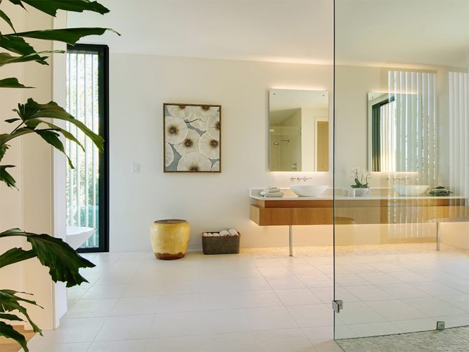 Entryway to the bathroom with the walk-in shower on the right and the two sinks/mirrors in front