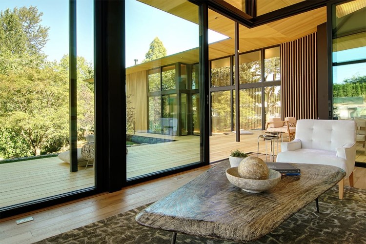 View from living room table outside into the outdoors through the floor to ceiling windows