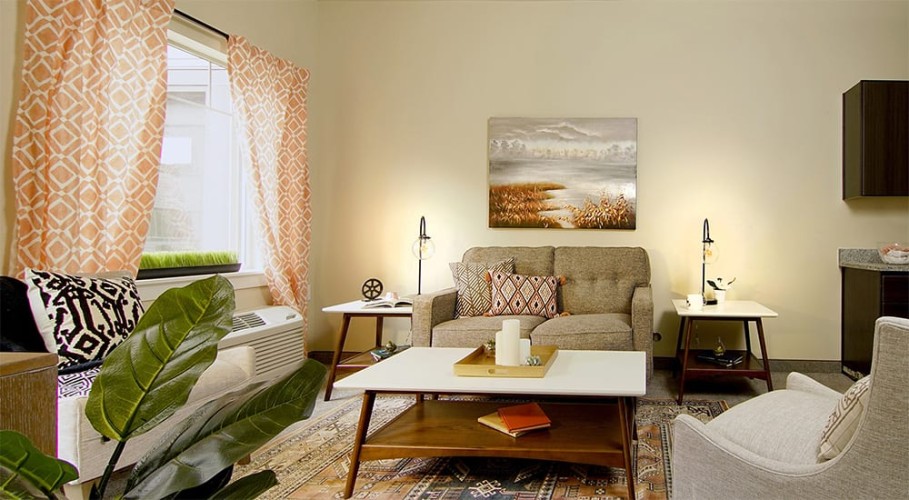 Small living room space with orange, gray and black accent colors facing the couch