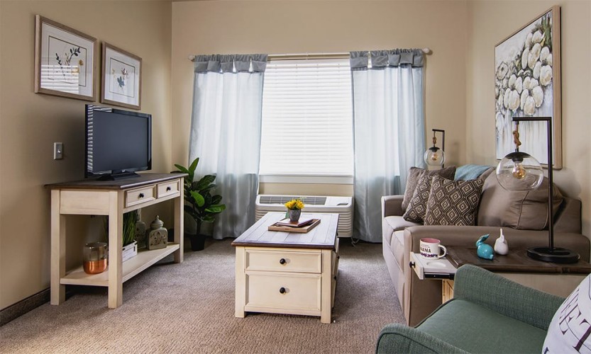 Small living room with brown, blue, and blue/green accent colors directly facing the windows