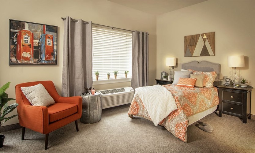 Small living space/bedroom with orange and gray accent colors