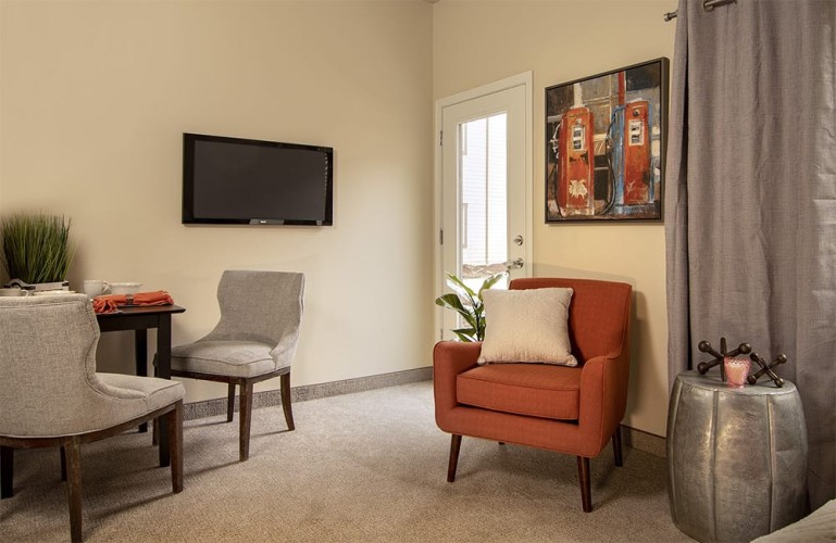 Small living space with orange and gray accent colors