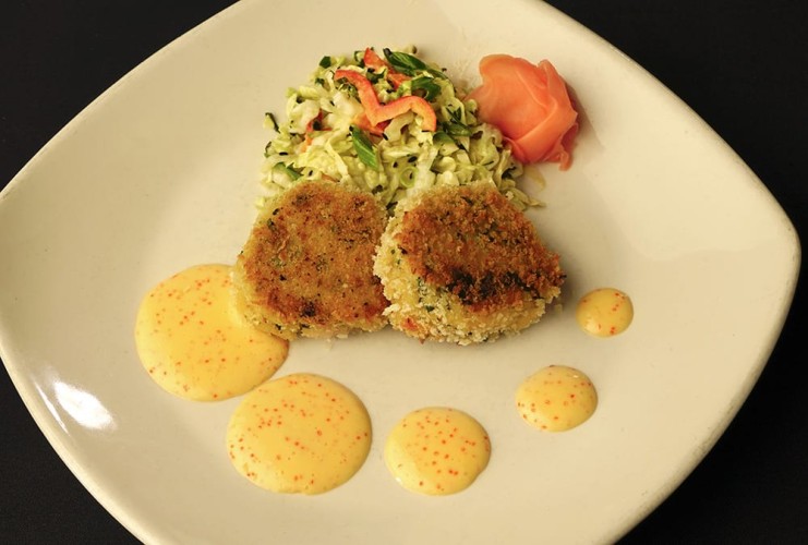 Crab puffs plated with artistic sauce and salad