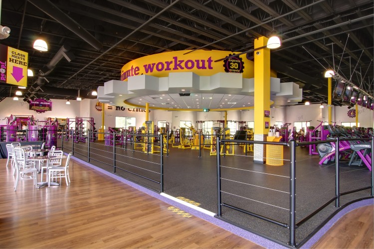 Interior of planet fitness with yellow and purple workout machines