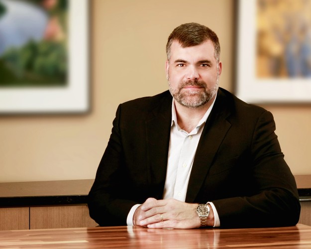 Portrait of a business man in a conference room wearing black with a white undershirt